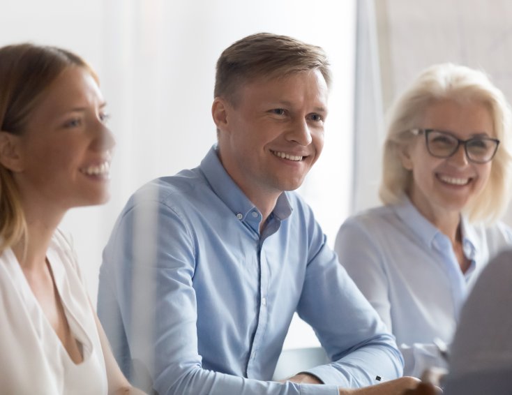 Gruppe med fire mennesker som smiler og ser på hverandre.