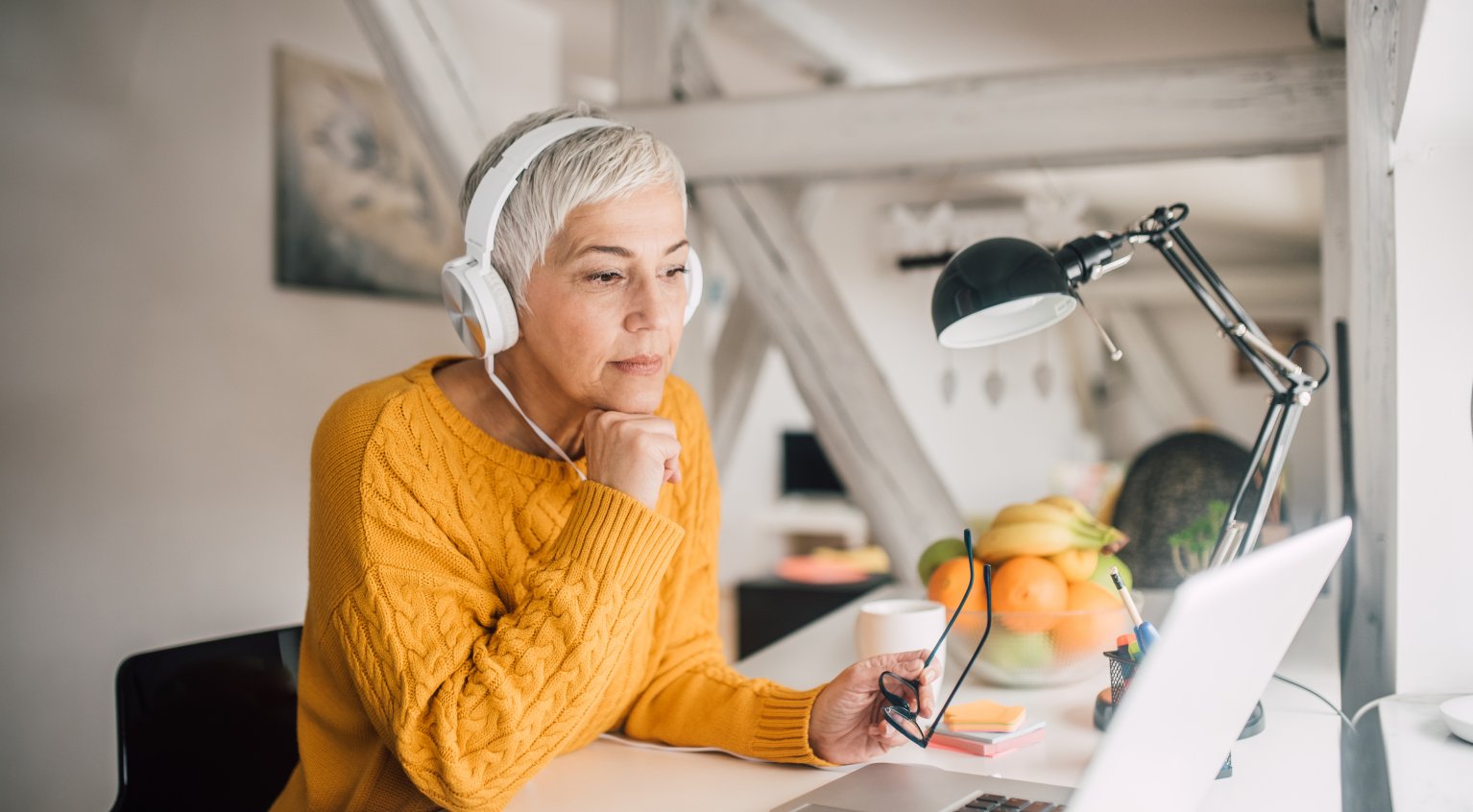 Jvinne sitter med headset og ser på PC