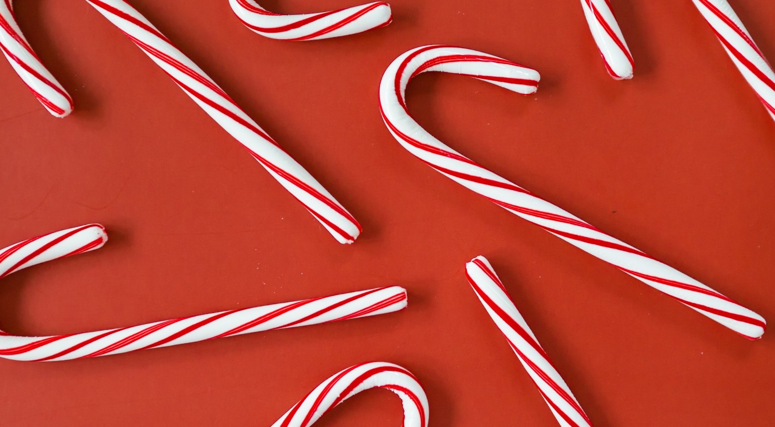 Bilde av røde og hvite "candy canes", på rød bakgrunn.