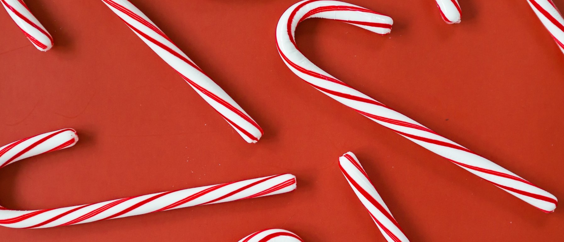 Bilde av røde og hvite "candy canes", på rød bakgrunn.