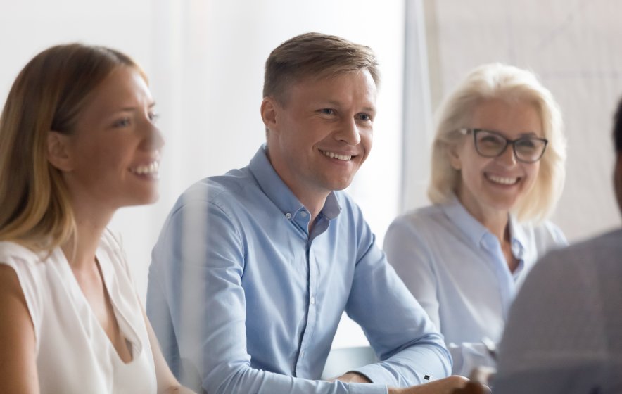 Gruppe med fire mennesker som smiler og ser på hverandre.