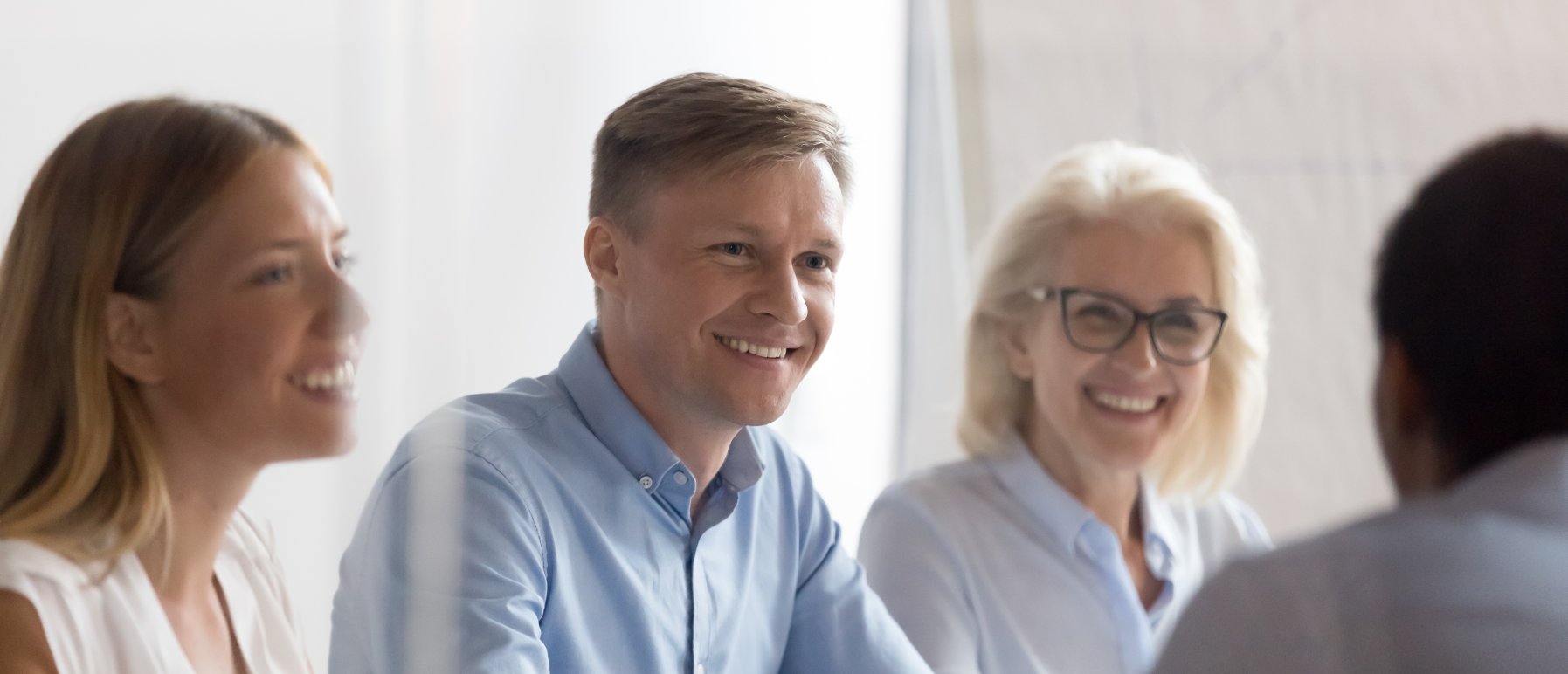 Gruppe med fire mennesker som smiler og ser på hverandre.