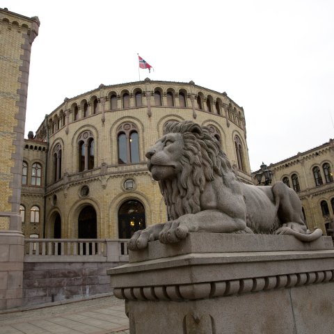 Bilde av Stortinget med løven i forgrunnen.